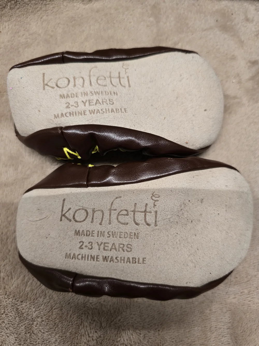 Konfetti Swedish Moccasins feature a beige sock top with a green lizard design
